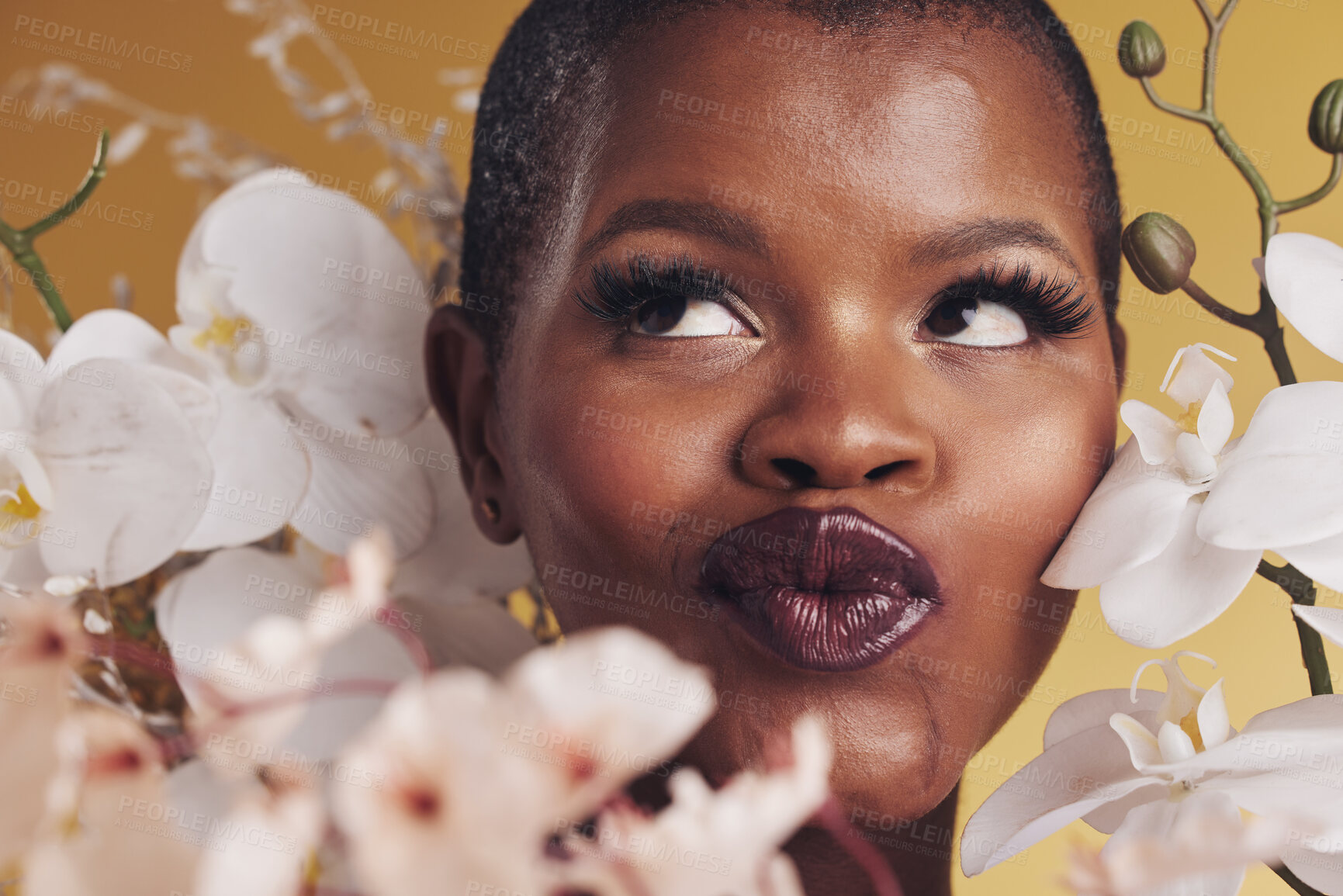 Buy stock photo Makeup, beauty and face of black woman with flowers for wellness, skincare and facial in studio. Spa, aesthetic and African person with orchids for natural cosmetics and glamour on yellow background