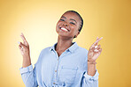 African woman, cross fingers and studio portrait for luck, excited smile or trendy clothes by yellow background. Young fashion model, happy student or sign language for hope, wish or dream of success