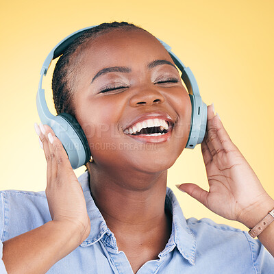 Buy stock photo Singing, music and black woman on headphones, smile and listening in studio isolated on a yellow background. Happy, radio and African person streaming podcast, audio and sound, hearing and freedom.