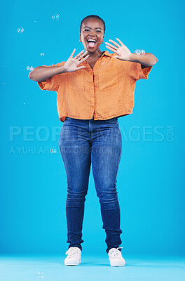Buy stock photo Excited, portrait and black woman on blue background with bubbles for happiness, joy and have fun. Playful, smile and isolated African person in studio with soap bubble for happy, magic and aesthetic