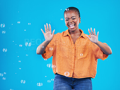 Buy stock photo Excited, laugh and black woman on blue background with bubbles for happiness, joy and have fun. Playful, happy smile and isolated African person in studio with soap bubble for freedom and color