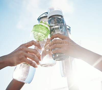 Buy stock photo Hands, water bottle and toast to fitness together after workout, exercise or training outdoor with team of players. Sport, goals and cheers with group and liquid for hydration, celebration and unity