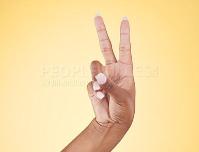 Buy stock photo Closeup, hands and peace sign with emoji, support and voice on a yellow studio background. Hand of female, person and model showing v symbol, icon or shape for hope, trust in vote and mockup space
