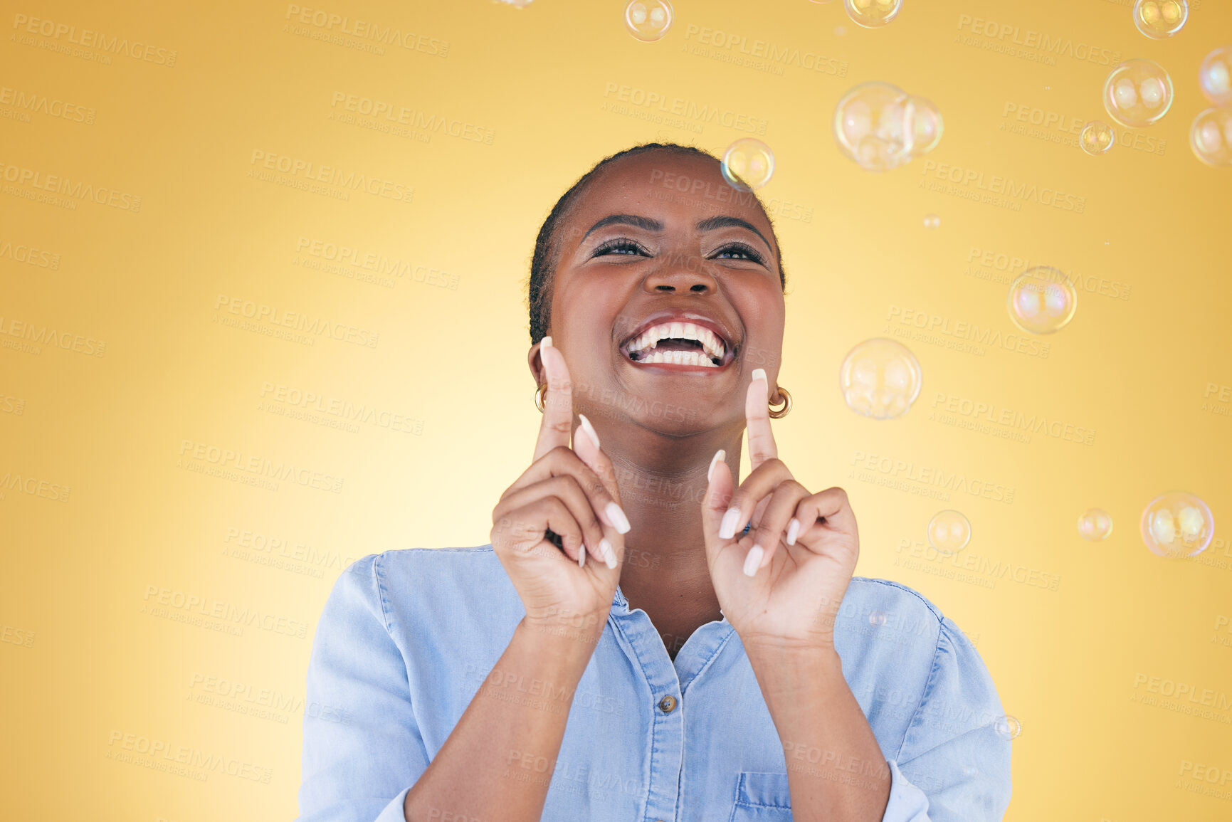 Buy stock photo Excited, happy and black woman on yellow background with bubbles for happiness, joy and fun. Playful laugh, smile and isolated African person in studio with soap bubble for freedom, magic and color