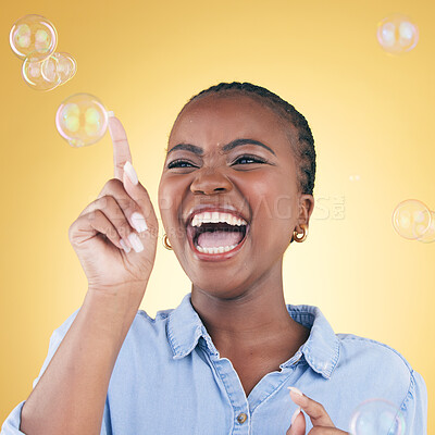Buy stock photo Excited, laugh and black woman on yellow background with bubbles for happiness, joy and have fun. Happy, smile and isolated African person in studio pop soap bubble for playful magic and color