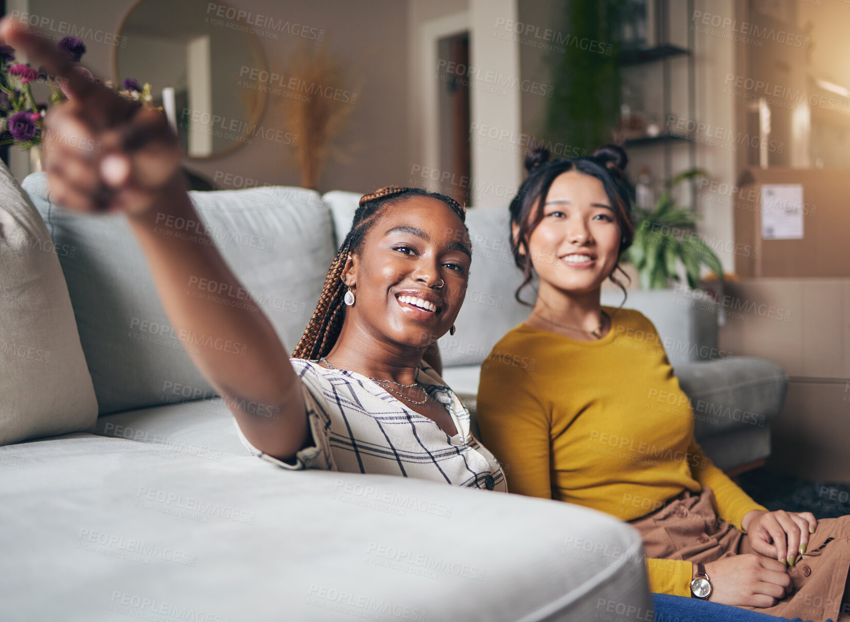 Buy stock photo Pointing, friends and women in living room for visit, bonding and conversation in apartment. Hand gesture, showing house decor and black female and Asian person in lounge to relax together on weekend