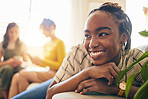 Happy, smile and black woman relaxing in the living room with her friends in her modern apartment. Happiness, positive and young African female person sitting in the lounge for rest at her home.