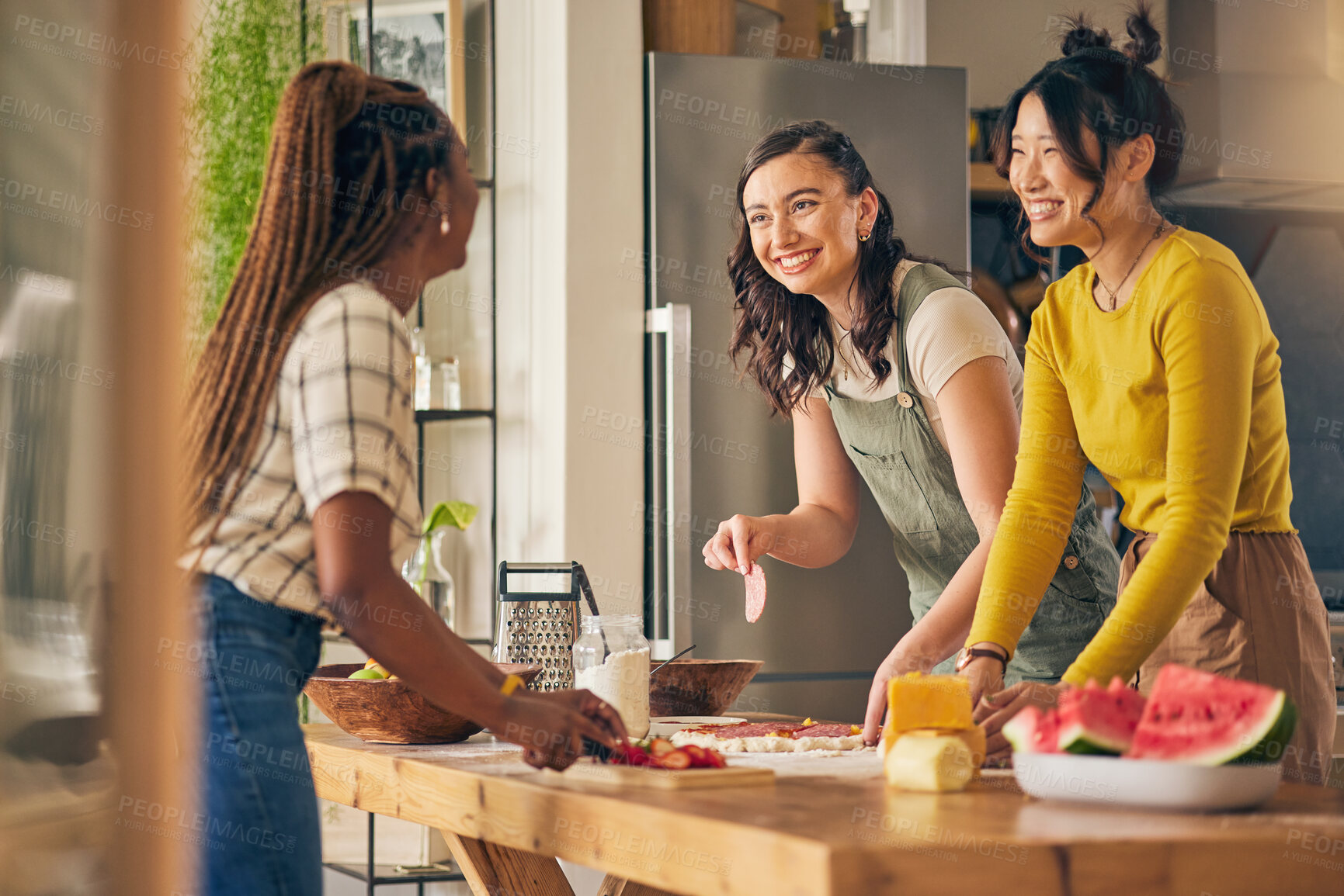 Buy stock photo Friends, smile and women cooking pizza in kitchen, bonding and having fun together in home. Happy, girls and baking food, margherita and salami bread at lunch, cheese on meat and brunch in house