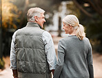 Relax, love and holding hands with old couple in nature for bonding, happy or peace. Smile, happiness and retirement with senior man and woman walking in countryside park for vacation and commitment 