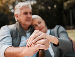 Holding hands, couple and a cane in nature for love, bonding and support. Peace, closeup and a senior man and woman in a park with a walking stick, care and together in a garden with a hug on a date