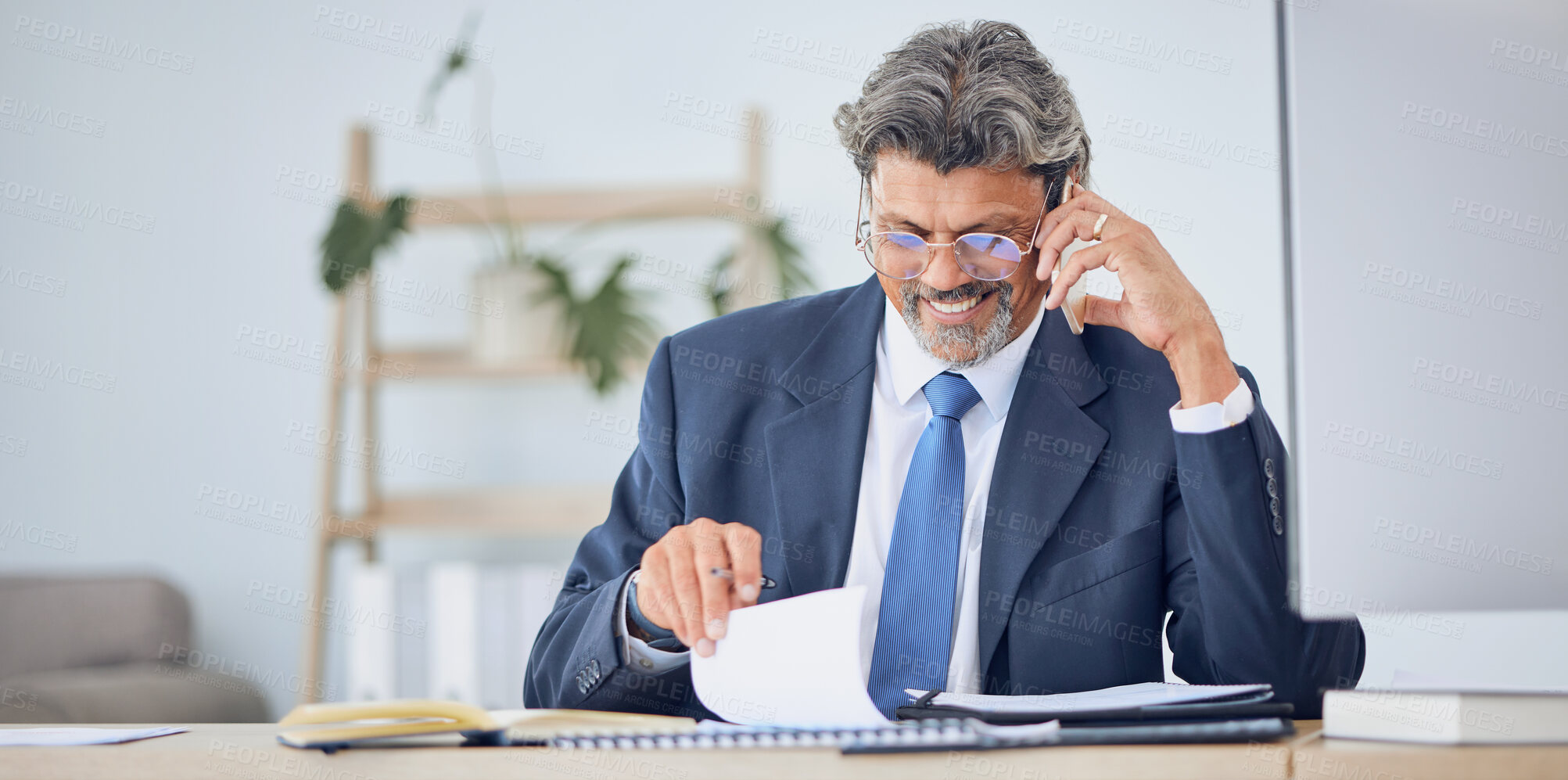 Buy stock photo Business man, reading documents and phone call for contract negotiation, legal advice and compliance at desk. Corporate lawyer, smartphone and data analysis with paperwork, notes and smile in office
