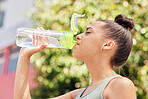 Woman, fitness and drinking water in nature for sustainability after workout, training or outdoor exercise. Thirsty female person with bottle for natural nutrition, mineral or liquid diet in the park