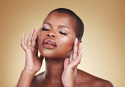 Buy stock photo Beauty, makeup and a black woman with hands on face in studio for skin care, glow and cosmetics. Headshot of african person or model with facial shine, dermatology and wellness on a beige background