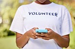 Person hands, phone typing and volunteering in park with social media FAQ, blog or community service chat. Volunteer on search mobile for earth day communication, NGO or nonprofit contact in nature