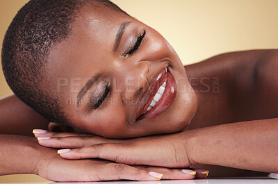 Buy stock photo Skin, beauty and makeup of a black woman in studio for self care, glow or cosmetics. Face of African aesthetic model person with facial shine, dermatology and head on hands on beige background