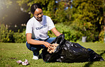 Volunteer, woman and cleaning waste in park for community service, pollution and climate change or earth day project. African person volunteering in garden, nature or outdoor and plastic bag or trash
