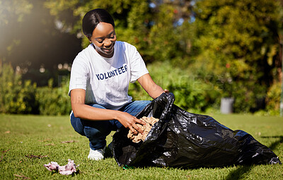 Buy stock photo Volunteer, woman and cleaning waste in park for community service, pollution and climate change or earth day project. African person volunteering in garden, nature or outdoor and plastic bag or trash