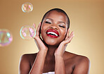 Beauty, makeup and bubbles with face of black woman in studio for cosmetics, spa treatment and luxury. Skincare, dermatology and self care with model on gold background for glow, facial and soap