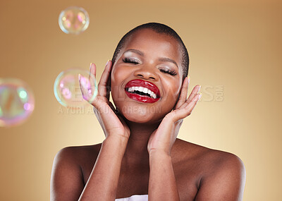 Buy stock photo Beauty, makeup and bubbles with face of black woman in studio for cosmetics, spa treatment and luxury. Skincare, dermatology and self care with model on gold background for glow, facial and soap