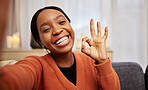 Selfie, black woman and ok hand sign at home with a smile for success, motivation and perfect. Portrait, happy and African female person in a living room with a like, yes and emoji gesture at house