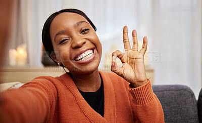 Buy stock photo Selfie, black woman and ok hand sign at home with a smile for success, motivation and perfect. Portrait, happy and African female person in a living room with a like, yes and emoji gesture at house