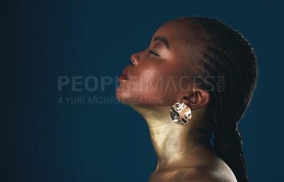 Buy stock photo Profile, beauty and black woman in gold for culture, heritage or tradition on a blue background in studio. Face, mockup and african style with a young model closeup for elegance or cosmetics