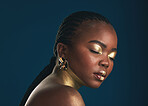 Gold makeup, studio face and black woman relax with creative art, facial cosmetics paint and beauty. African culture, color and person with eyes closed, wellness and creativity on blue background