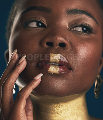 Buy stock photo Face, beauty and black woman in gold for culture, heritage or tradition on a blue background in studio. Skincare, makeup and african style with a young model closeup for elegance or cosmetics