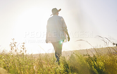 Buy stock photo Back, agriculture and a woman walking on a farm for sustainability or growth in the morning with flare. Farming, sunrise and female farmer on a nature landscape for eco friendly harvesting in season