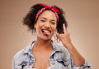Buy stock photo Woman, horns sign and studio portrait with tongue, comic smile and funny face with beauty by brown background. African girl, model or student with icon, crazy and rock star hand with laugh for beauty