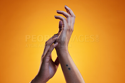 Buy stock photo Hands, touch and skin care of a woman in studio with dermatology cosmetics and a manicure. Beauty salon, spa and a person on an orange background for wellness, health and clean body or hygiene