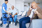 Senior, doctor and a man with a headache in a nursing home, depression or pain consultation. Talking, help and a nurse with elderly people for support with a migraine, retirement stress or sick