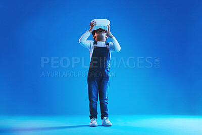 Buy stock photo Glasses, virtual reality and metaverse with girl, online games or digital transformation on blue studio background. Kid, child and model with vr headset with technology, futuristic and live streaming