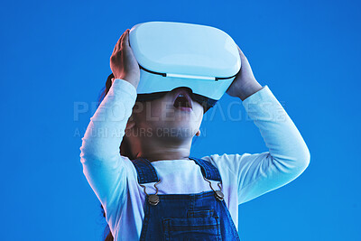 Buy stock photo Wow, virtual reality and metaverse with girl, glasses and online gaming on a blue studio background. Person, kid or child with vr headset, augmented reality or digital transformation with video games