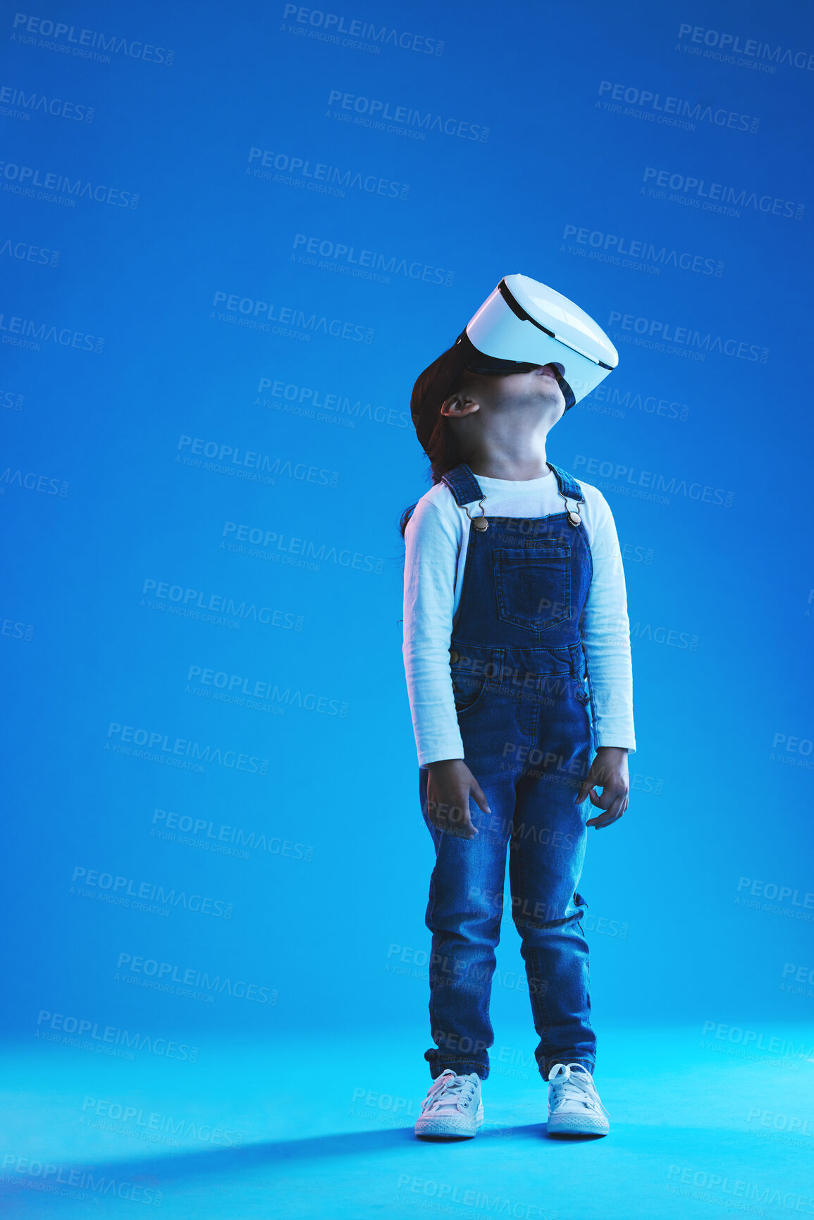 Buy stock photo Glasses, virtual reality and metaverse with girl, future and digital transformation on a blue studio background. Kid, mockup space and model with vr headset for video games, futuristic and innovation