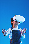 Metaverse, girl and child virtual reality glasses, innovation and future on a blue studio background. Kid, vr headset or technology for online gaming, futuristic and augmented reality with connection