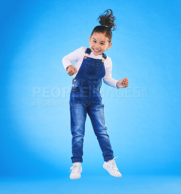 Buy stock photo Happy, jumping and portrait of a child in a studio with excitement, joy or wow expression. Happiness, smile and full length of a girl kid model moving for good news isolated by a blue background.