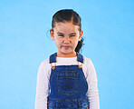 Tantrum, attitude and portrait of child on blue background with upset, mad and frustrated facial expression. Behaviour, pout and young girl with sad face for anger, tantrum and problem in studio