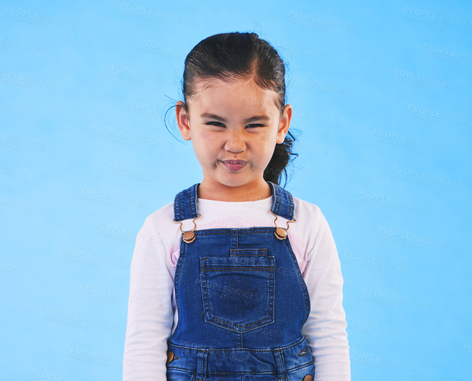 Buy stock photo Tantrum, attitude and portrait of child on blue background with upset, mad and frustrated facial expression. Behaviour, pout and young girl with sad face for anger, tantrum and emotion in studio