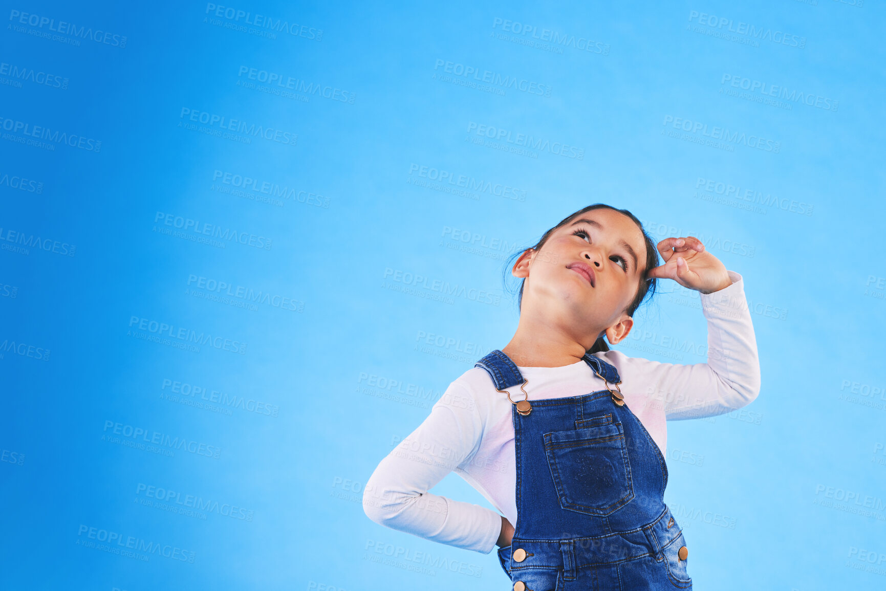 Buy stock photo Children, thinking and a girl on a blue background mockup in studio for marketing or advertising. Banner, space and idea with a cute young child posing for a decision on kids fashion or style