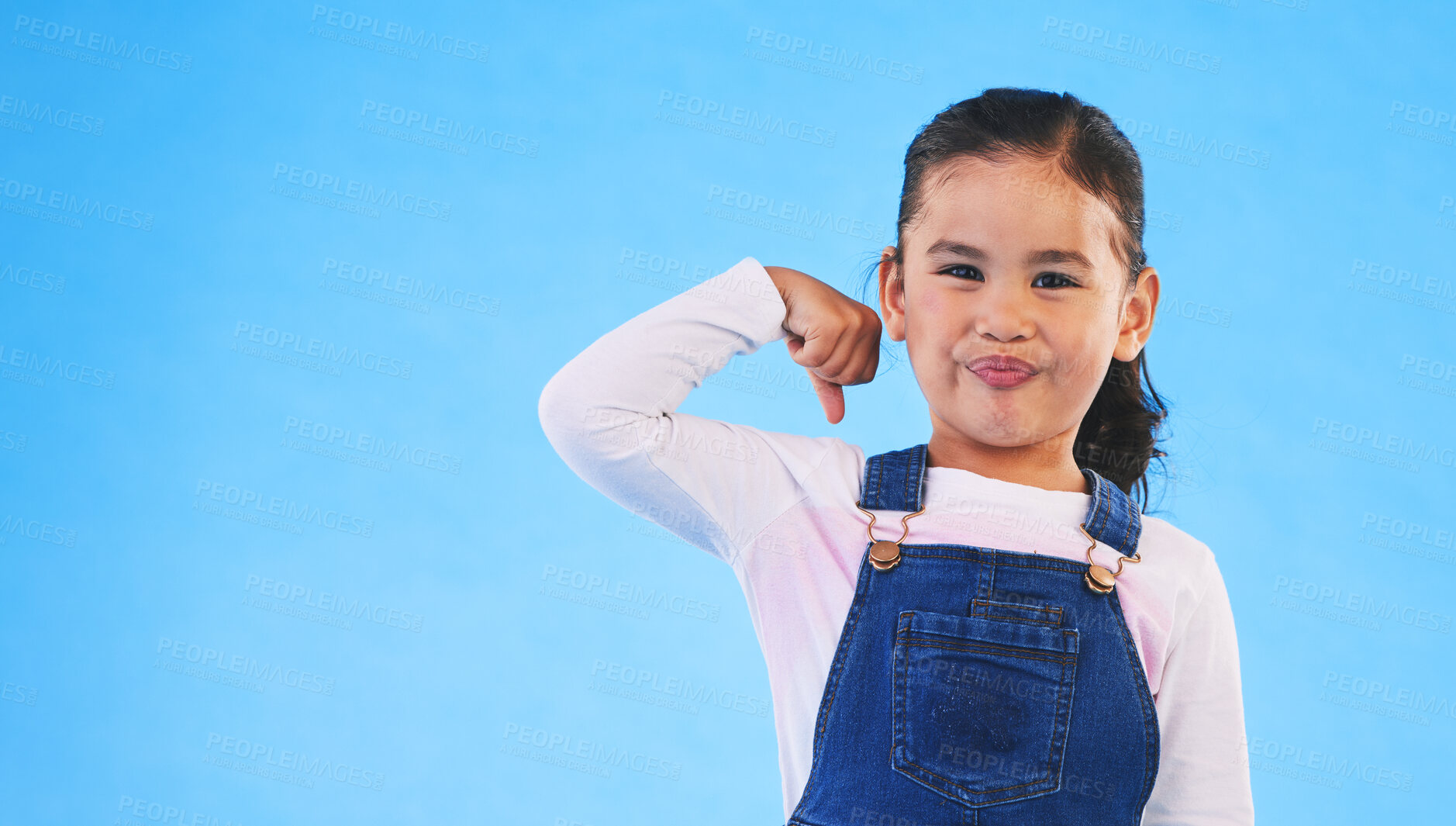 Buy stock photo Portrait, girl child and champion, winner and emoji with happiness, strong and excited isolated on blue background. Power, mockup space and winning with success, body language and happy kid in studio