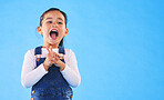 Excited, youth and a child on a blue background with mockup for information. Playful, freedom and a young girl kid or model playing with happiness on a studio background with space for creativity