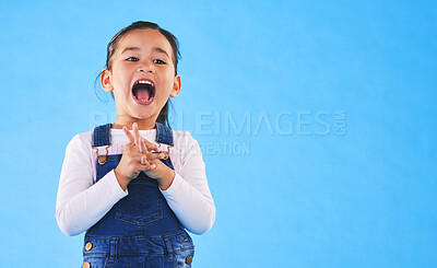 Buy stock photo Excited, youth and a child on a blue background with mockup for information. Playful, freedom and a young girl kid or model playing with happiness on a studio background with space for creativity