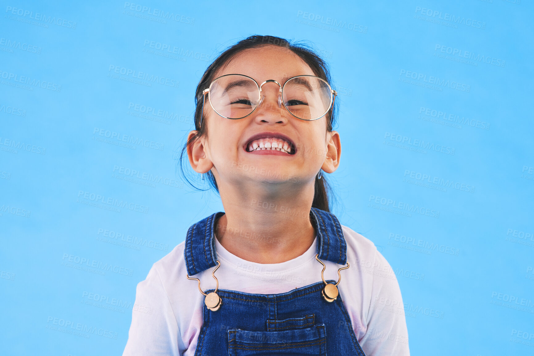 Buy stock photo Glasses, student smile and Asian child in portrait in studio isolated on a blue background mockup space. Happy, nerd and face of school kid, girl or geek in casual clothes, fashion and style in Japan