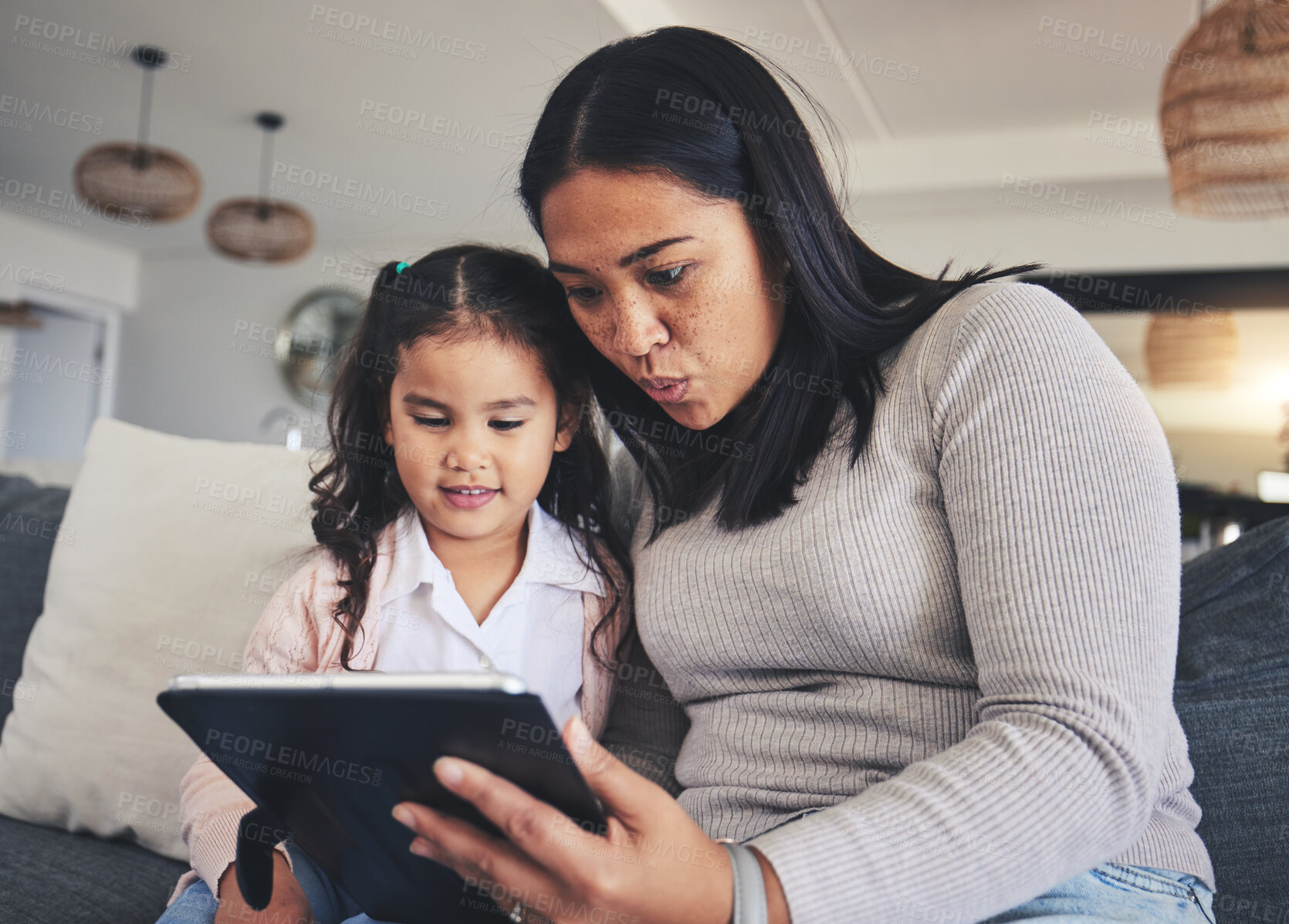 Buy stock photo Tablet, study and a mother on the sofa with her daughter in the living room of their home together. Education, family or children with a mother and girl looking at online homework for learning