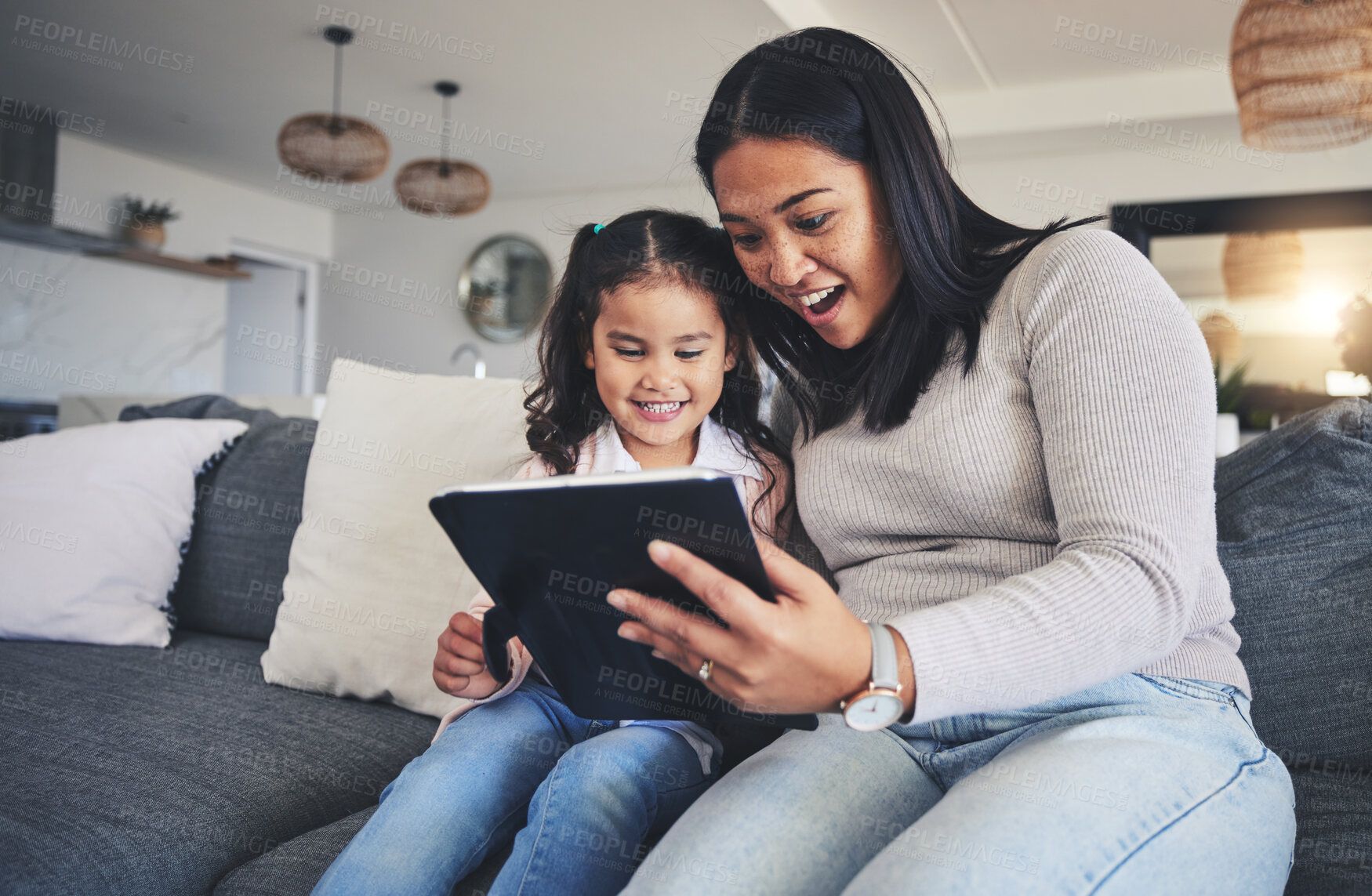 Buy stock photo Tablet, surprise and a mother on the sofa with her daughter in the living room of their home together. Wow, family or children with a mother and girl looking at social media or a good news email