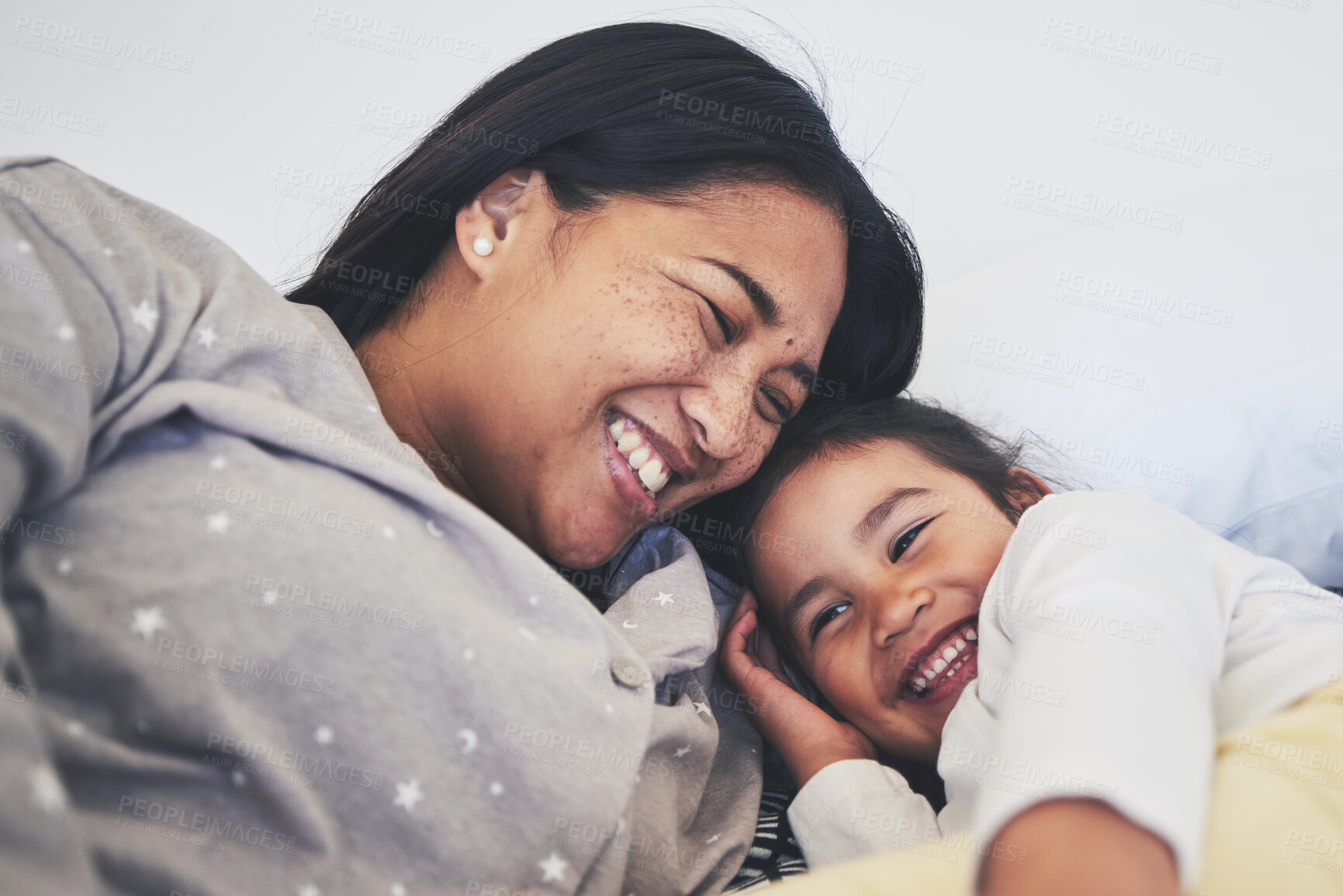 Buy stock photo Laugh, mother and daughter in bed at home with love, care and happiness in morning. A young woman and girl child together in a bedroom for fun time, playing and security or relax in a family house