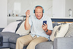 Headphones, phone and old man in living room dancing on sofa, listening to streaming radio and relax. Music, fun and excited senior person on couch with cellphone, earphones and online in retirement.