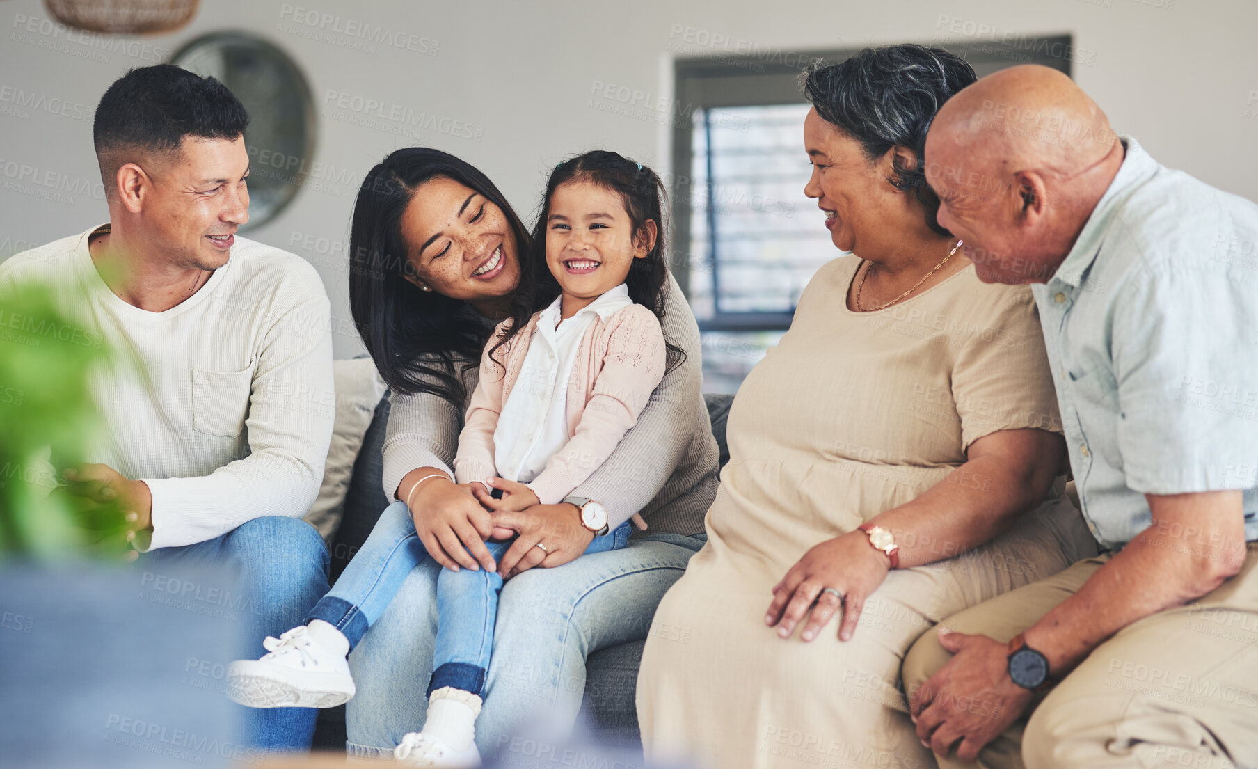 Buy stock photo Happy, care and a big family on the sofa with a child during a visit for love, bonding and playing. Smile, laughing and a girl kid with parents and grandparents on the home couch to relax and talk