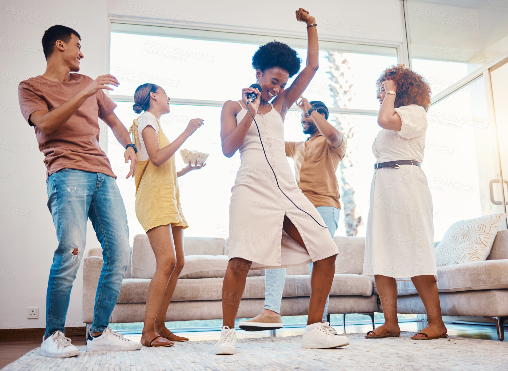 Buy stock photo Happy, party and people singing karaoke in the living room with a microphone to music, playlist or radio. Entertainment, diversity and young friends dancing, bonding and having fun together at home.